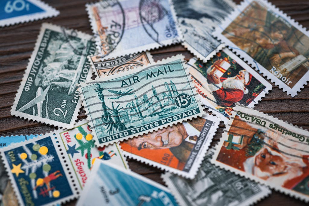 Close-up of assorted vintage postage stamps from different countries on a wooden surface.