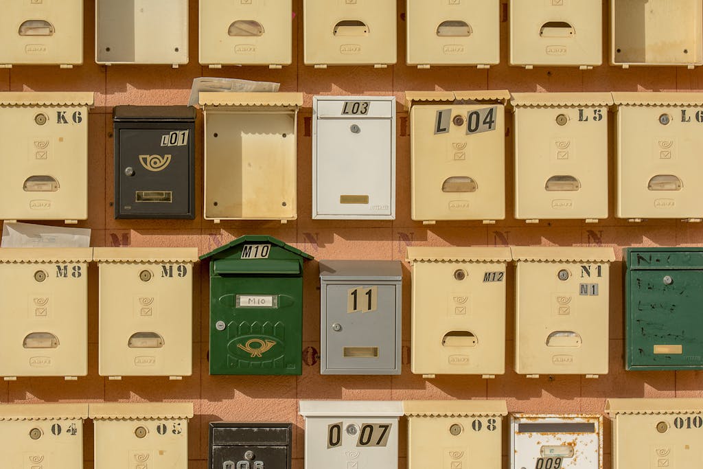 Colorful mailboxes arranged on a brick wall, showcasing vintage postal charm.
